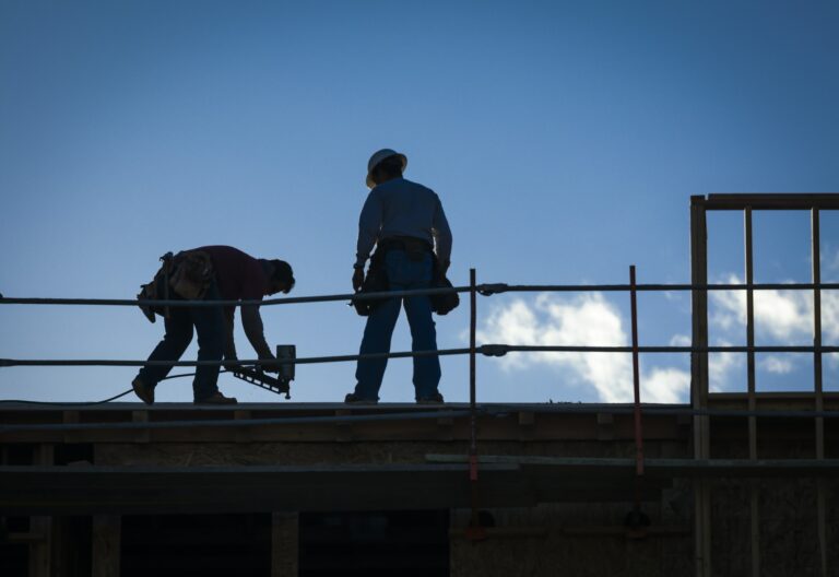 Construction Workers Silhouette on While Working on Commercial Roofing Replacements. - Commercial Roofing in Big Spring