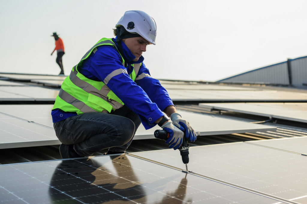 Construction worker conduction Commercial Roofing Repairs on a metal roof.