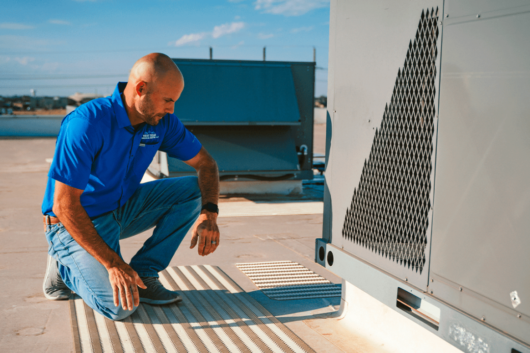 Chase McDonald inspecting transitions from HVAC unit build-up on TPO roof